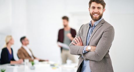 Businessman, portrait and coworking workplace for creative job, happy employee and company goals with vision for growth. People, office and business meeting, project manager and happy male person.